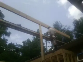 Carpenter setting a ridge beam over a new addition frame — Ice Dam Removal by Roofing Brothers in Dorothy