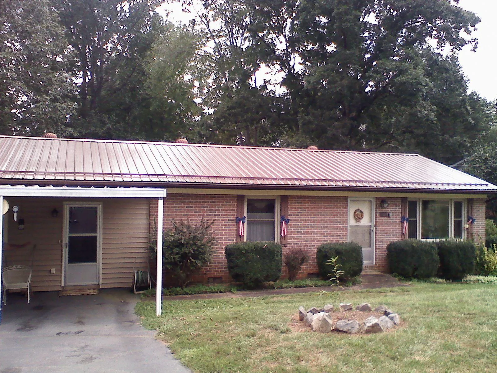 Bronze metal roof and carport on a brick ranch home — Roof Repair work by our crew in Dorothy